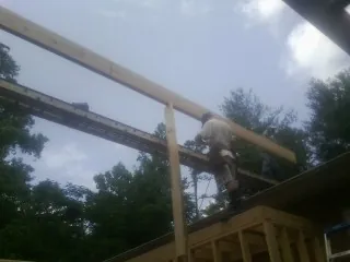 Carpenter setting a ridge beam over a new addition frame — Ice Dam Removal by Roofing Brothers in Sterling Forest