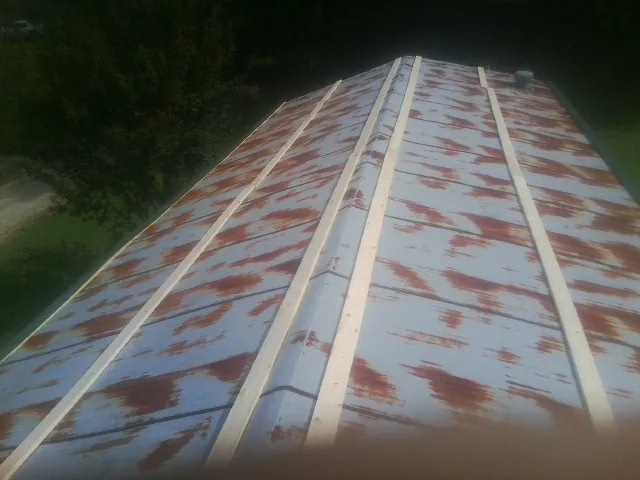 Rusted metal roof panels with new wood purlins before replacement — Storm Damage Roof Repair in Sterling Forest by Roofing Brothers