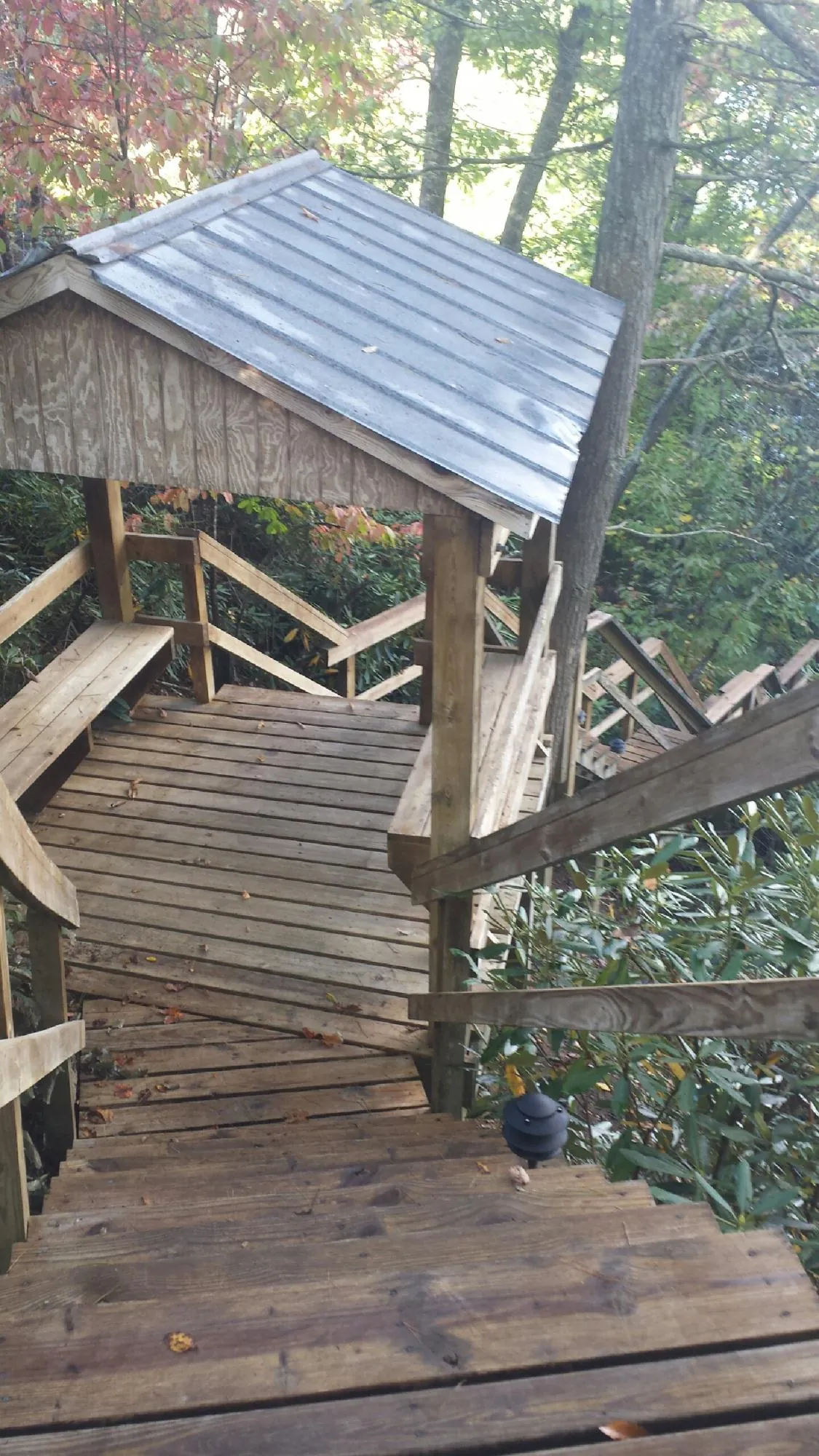 Metal roofed shelter over wooden steps on a wooded walkway — Skylight Repair & Installation work by our crew in Sterling Forest