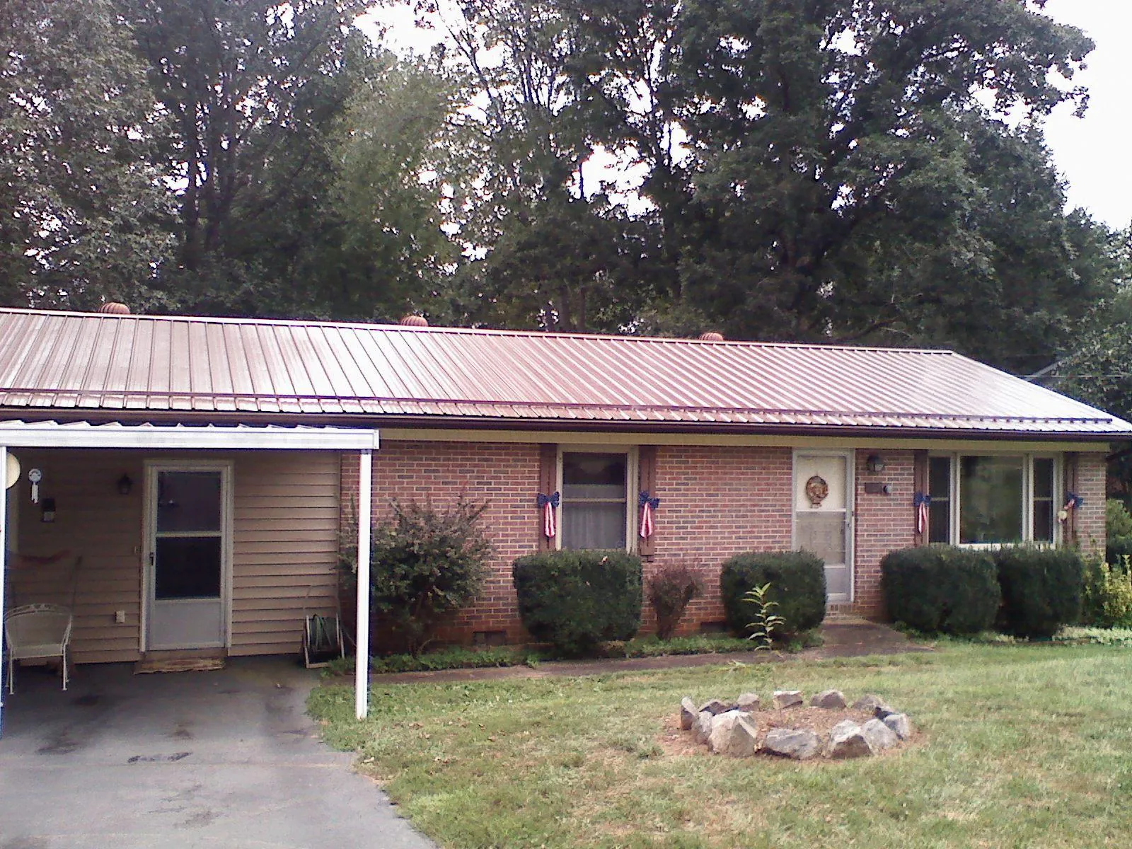 Bronze metal roof and carport on a brick ranch home — Roof Repair work by our crew in Sterling Forest